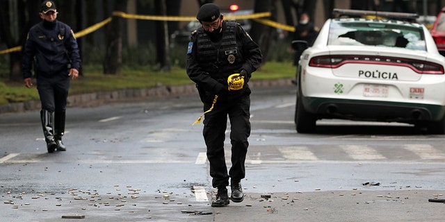 A police officer walks amid ammunition near the scene of a shooting in Mexico City, Mexico