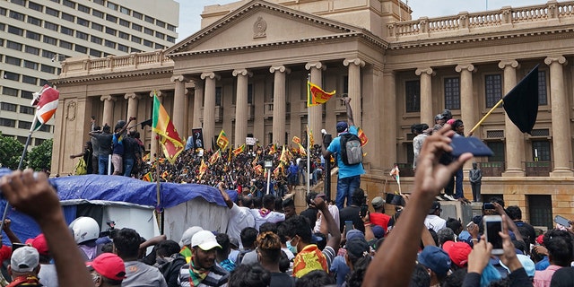 Protesters, many carrying Sri Lankan flags, gather outside the president's office in Colombo, Sri Lanka, Saturday, July 9, 2022. Sri Lankan protesters stormed President Gotabaya Rajapaksa's residence and nearby office on Saturday as tens of thousands of people took to the streets of the capital Colombo in the biggest demonstration yet to vent their fury against a leader they hold responsible for the island nation's worst economic crisis. (AP Photo/Thilina Kaluthotage)