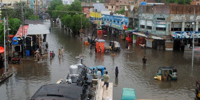 People in Pakistan struggle to make their ways through flooded streets after monsoon rains triggered flash floods in in Hyderabad, Pakistan, on Wednesday, Aug. 24, 2022.