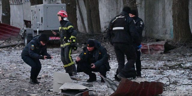 Rescuers and police experts examine remains of a drone following a strike on an administrative building in the Ukrainian capital Kyiv on Dec. 14, 2022.